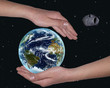 hands covering the world from a meteorite