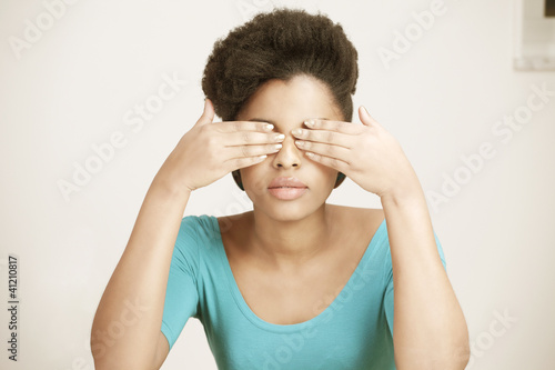Photo: Young woman closing eyes with hands Young woman closing eyes with hands