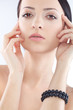 brunette woman with black pearl bracelet on hand