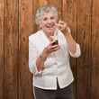 portrait of senior woman eating chocolate and cream cup against