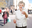 portrait of healthy senior woman holding a water bottle at stree