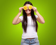 portrait of young woman holding orange slices in front of her ey portrait of young woman holding orange slices in front of her ey