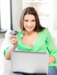 happy woman with laptop computer and credit card