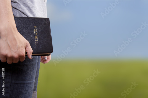 Photo: Standing Holding the Bible in a Field Standing Holding the Bible in a Field
