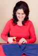 Hispanic woman cutting a piece of fabric Hispanic woman cutting a piece of fabric