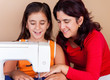 Mother and daughter sewing together Mother and daughter sewing together