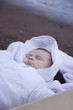 Photo: baby wrapped up sleeping in wooden box by sea baby wrapped up sleeping in wooden box by sea