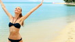 Happy woman walking on the exotic beach in the summertime