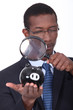 black well dressed man watching a piggy bank