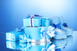 beautiful gifts and baby's bootees on blue background