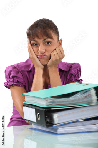 Foto: Bored businesswoman with a pile of folders Bored businesswoman with a pile of folders
