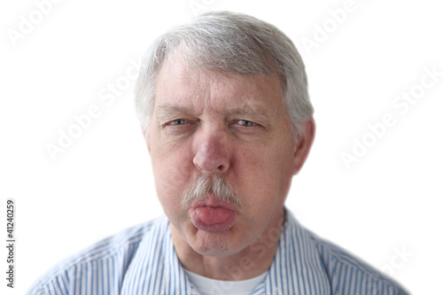 Photo: an older man blows a raspberry in a rude gesture an older man blows a raspberry in a rude gesture