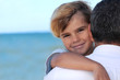 father holding his son on the beach