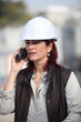 canvas print picture - middleaged female architect making a call in construction site