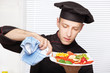 Chef cleaning edge of a fruit plate with cloth Chef cleaning edge of a fruit plate with cloth