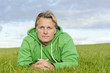 pensive looking man laying on grass pensive looking man laying on grass