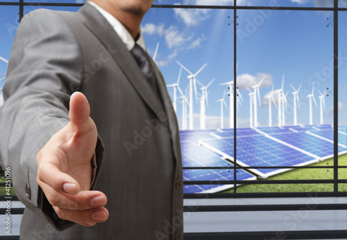 Photo: business man offers hand shake with energy saving business man offers hand shake with energy saving