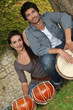 Couple playing the drums outside