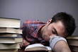 Young man sleeping on books