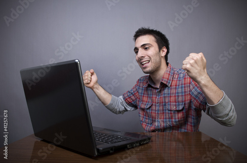 Foto: Joyful young man with laptop Joyful young man with laptop