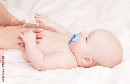 Photo: Mother massaging baby Mother massaging baby