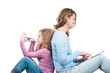 Mother and daughter sitting with phone and tablet.