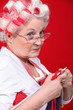 Old lady wearing hair rollers and knitting