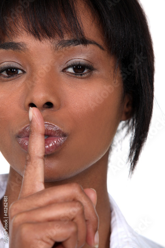 Photo: Woman holding her finger to her lips Woman holding her finger to her lips