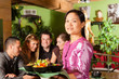 Junge Leute mit Bedienung essen in einem Thai Restaurant