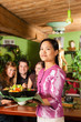 Junge Leute mit Bedienung essen in einem Thai Restaurant