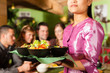 Junge Leute mit Bedienung essen in einem Thai Restaurant