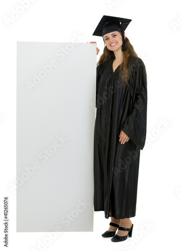 Photo: Happy graduation student holding blank billboard Happy graduation student holding blank billboard