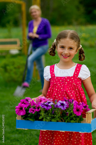 Photo: Gardening - lovely girl helping mother in the garden Gardening - lovely girl helping mother in the garden