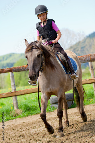 Photo: Horse riding - lovely girl is riding a horse Horse riding - lovely girl is riding a horse