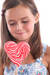 Little girl with heart-shaped lollipop