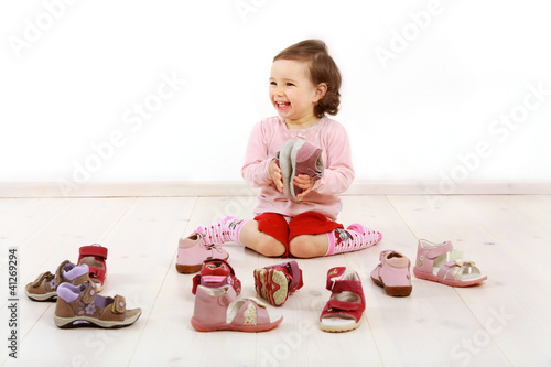 Photo: Kleinkind freut sich über ein Paar Schuhe Kleinkind freut sich über ein Paar Schuhe