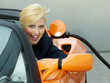 Woman sits in electrically powered car at the service station