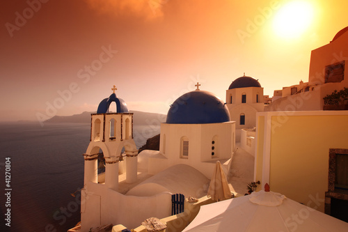 Photo: Santorini with famous churches against in Oia village, Greece Santorini with famous churches against in Oia village, Greece