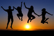 silhouette of kids jumping on beach in sunset