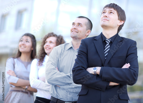 Photo: business team standing in a row at office and looking upwards business team standing in a row at office and looking upwards