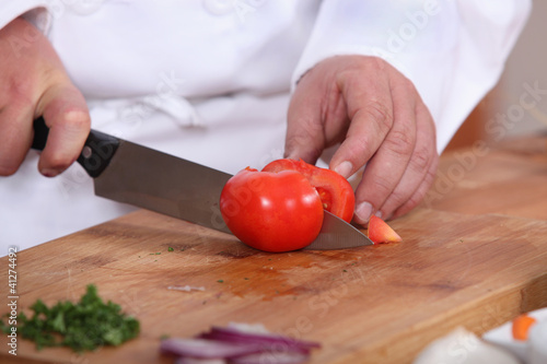 Photo: Cook cutting a tomato Cook cutting a tomato