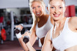 two fitness women doing dumbbell exercise in gym two fitness women doing dumbbell exercise in gym