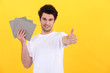 Man holding tiles on yellow background