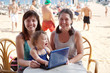 women and girl with laptop at beach women and girl with laptop at beach