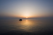 Small fishing boat at sunrise on a calm sea Small fishing boat at sunrise on a calm sea