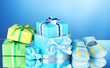 beautiful gifts and baby's bootees on blue background