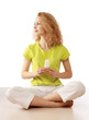 Woman with energy-saving bulb sitting cross-legged on floor.