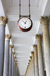 Round clock in a colonnade