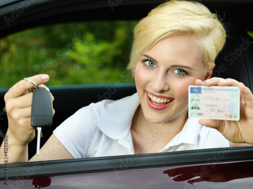 Photo: Woman sitting in car is happy getting a driver licence Woman sitting in car is happy getting a driver licence