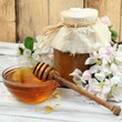 Honey in a glass jar and flower on a wooden table Honey in a glass jar and flower on a wooden table